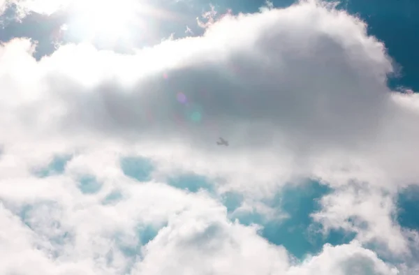 Güneş ve kümülüs beyaz bulutlar güzel mavi gökyüzü, sinek uçak karşı