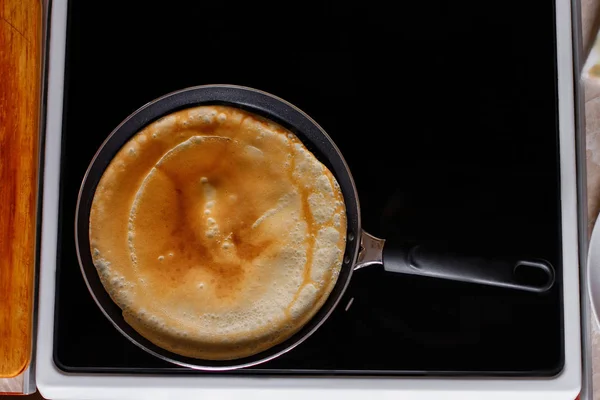 Cooking pancakes in the kitchen. Pancake in the pan. Top view. Flat lay.