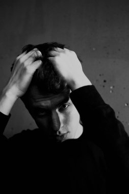 Siyah ve beyaz duygusal bir adam portresi. Dramatik fotoğraf. Işık penceresinden. Düşük anahtar.