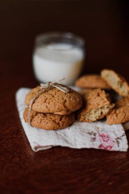 Bir sürü kurabiye masanın üzerinde. Bir bardak süt. Ahşap bir masa çerezleri. Sağlıklı bir yaşam tarzı. Sabah, kahvaltı. Üstten görünüm