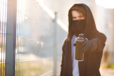 Kukuletalı adam maskesi çizim grafiti tarafından sprey boya ile olabilir. Grafiti sanatçısı çiziyor. Aerosol vandalizm portre. Kentsel kavramı. Güneş ışığı