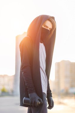 Kukuletalı adam maskesi çizim grafiti tarafından sprey boya ile olabilir. Grafiti sanatçısı çiziyor. Aerosol vandalizm portre. Kentsel kavramı. Güneş ışığı