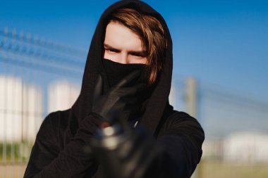 Adam maske ve eldiven bir sprey boya ile olabilir tutuyor. Sokak vandalizm, kentsel tarzı. Grafiti çizimler. Aerosol elinde.