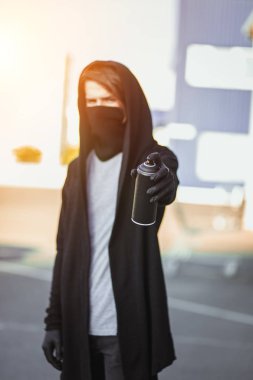 Adam maske ve eldiven bir sprey boya ile olabilir tutuyor. Sokak vandalizm, kentsel tarzı. Grafiti çizimler. Aerosol elinde.