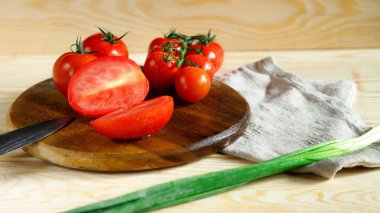 Taze domates mutfakta kesme tahtası üzerinde bıçak ile kesme.