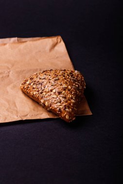 Lezzetli üçgen topuz kağıt üzerinde tohumları ile. Koyu arka plan