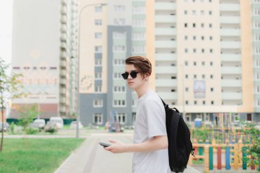 Kamera için güneş gözlüğü ve elinde telefon ile arayan adam. Kentsel bakmak