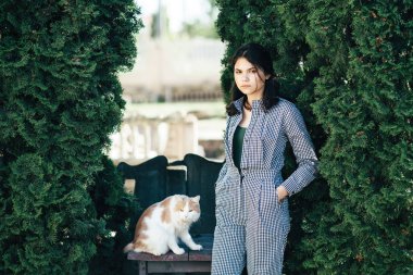 Sevimli kız Benekli kedi onun kollarında tutar.