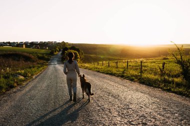 Güzel bir kız yolun yanında bir köpek yol açar..