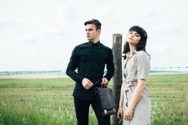 Sevimli genç adam bir şehir arkasında yeşil bir arka plan üzerinde güzel bir kızın yanında ayakta.