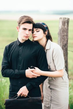 Sevimli genç adam bir şehir arkasında yeşil bir arka plan üzerinde güzel bir kızın yanında ayakta.
