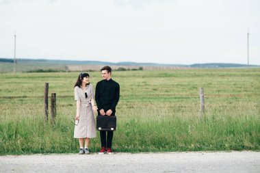 Hoş bir genç adam bir iş çantası kimin elinde güzel bir kız yanında duruyor.