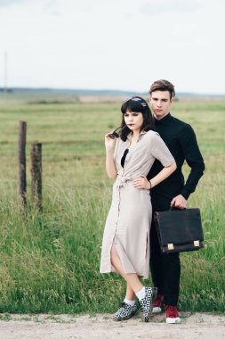 Hoş bir genç adam bir iş çantası kimin elinde güzel bir kız yanında duruyor.