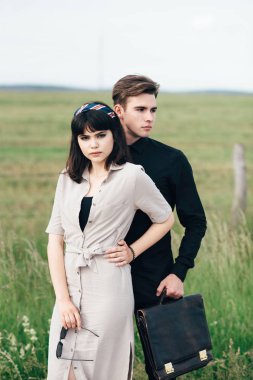 Hoş bir genç adam bir iş çantası kimin elinde güzel bir kız yanında duruyor.