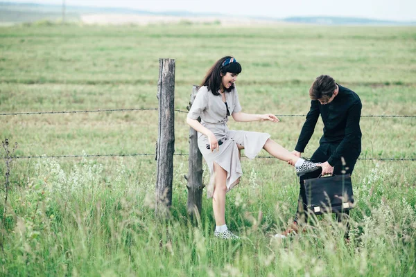 Sevimli genç adam bir şehir arkasında yeşil bir arka plan üzerinde güzel bir kızın yanında ayakta.