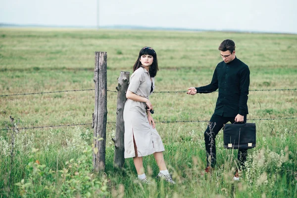 Sevimli genç adam bir şehir arkasında yeşil bir arka plan üzerinde güzel bir kızın yanında ayakta.