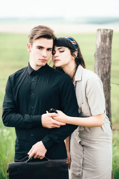 Cute young guy standing next to a beautiful girl on a green background behind a city.
