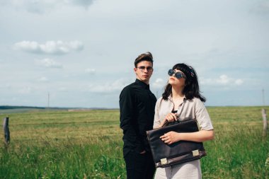 Hoş bir genç adam bir iş çantası kimin elinde güzel bir kız yanında duruyor.