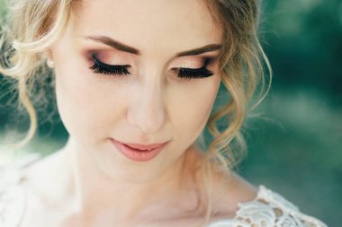 Parkta ellerinde düğün buketi olan güzel bir gelin. Düğün günü.