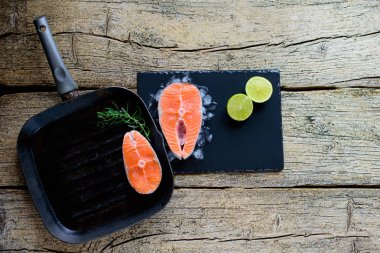 İki somon biftek kireç ahşap arka plan üzerinde birlikte bir ızgara üzerinde pişirmek hazırsınız demektir. Üstten görünüm. Sağlıklı gıda.