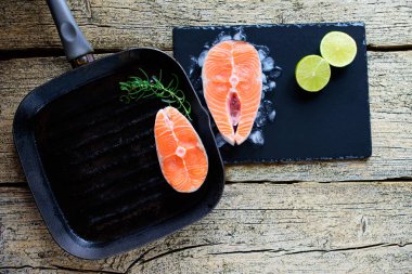 İki somon biftek kireç ahşap arka plan üzerinde birlikte bir ızgara üzerinde pişirmek hazırsınız demektir. Üstten görünüm. Sağlıklı gıda.