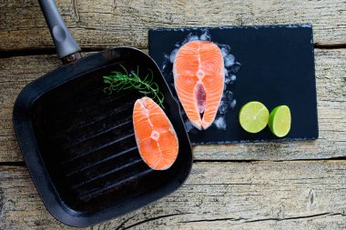 İki somon biftek kireç ahşap arka plan üzerinde birlikte bir ızgara üzerinde pişirmek hazırsınız demektir. Üstten görünüm. Sağlıklı gıda.