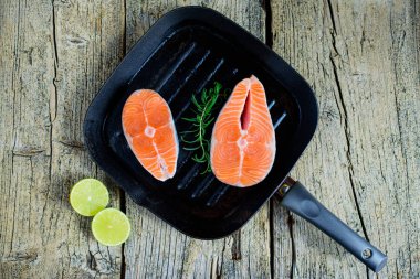 İki somon biftek kireç ahşap arka plan üzerinde birlikte bir ızgara üzerinde pişirmek hazırsınız demektir. Üstten görünüm. Sağlıklı gıda.