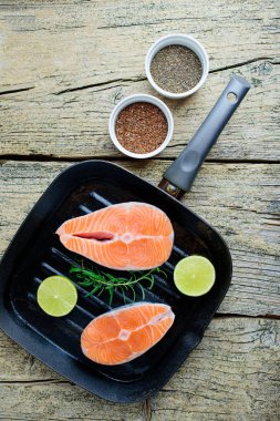 İki somon biftek kireç ve chia ve ahşap zemin keten tohumu ile birlikte bir ızgara üzerinde pişirmek hazırsınız demektir. Üstten görünüm. Sağlıklı gıda.