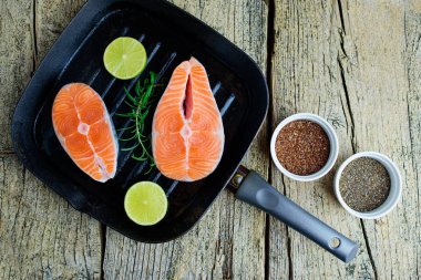 İki somon biftek kireç ve chia ve ahşap zemin keten tohumu ile birlikte bir ızgara üzerinde pişirmek hazırsınız demektir. Üstten görünüm. Sağlıklı gıda.