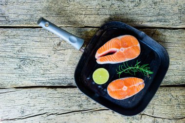 İki somon biftek kireç ahşap arka plan üzerinde birlikte bir ızgara üzerinde pişirmek hazırsınız demektir. Üstten görünüm. Sağlıklı gıda.