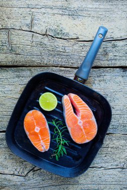 İki somon biftek kireç ahşap arka plan üzerinde birlikte bir ızgara üzerinde pişirmek hazırsınız demektir. Üstten görünüm. Sağlıklı gıda.