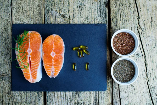 Two Salmon Steaks Lie Black Board Alongside Vitamins Seeds Chia — Stock Photo, Image