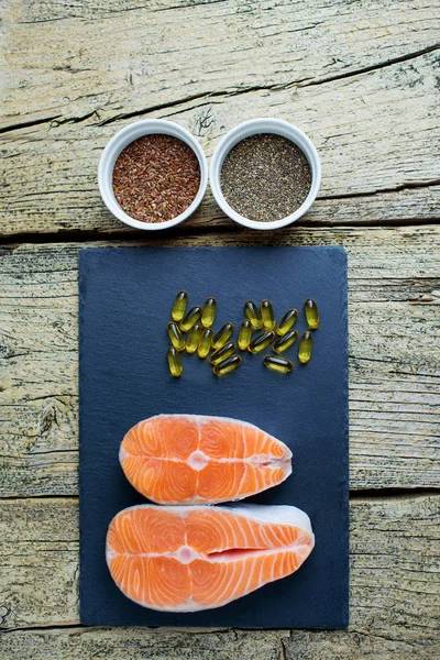 Two Salmon Steaks Lie Black Board Alongside Vitamins Seeds Chia — Stock Photo, Image