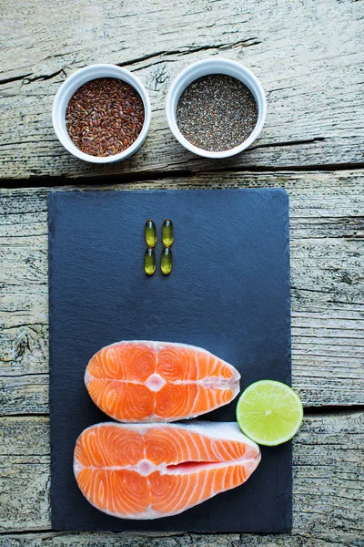 Two Salmon Steaks Lie Black Board Alongside Vitamins Seeds Chia — Stock Photo, Image