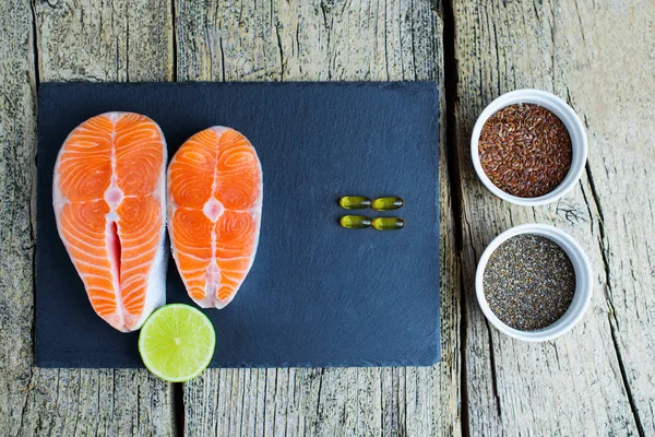 Two Salmon Steaks Lie Black Board Alongside Vitamins Seeds Chia — Stock Photo, Image