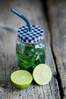 Narenciye meyve ve otlar sassi su detoks ya da ahşap tahta, koyu arka plan üzerinde cam şişelerde diyet için infüzyon.