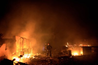 Orman yangını gece kavga itfaiyeci silüeti.