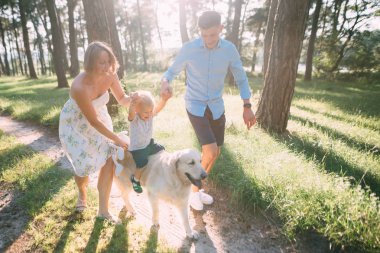 Şirin bir aile - anne, baba ve oğlu eğlenceli harcamak zaman açık havada ile onların köpek.