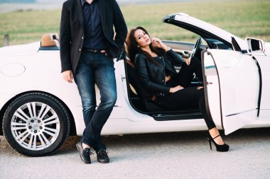 Kadın ve erkek tipik bir çift beyaz bir araba yanında şehir dışında vakit geçirmek.