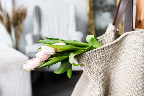 Un hermoso ramo de tulipanes rosados frescos en una bolsa grande en el fondo de la sala de estar — Foto de Stock