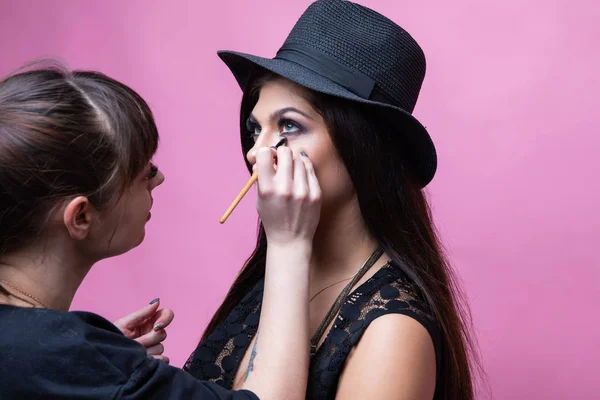 Візажист робить макіяж для красивої і молодої дівчини — стокове фото
