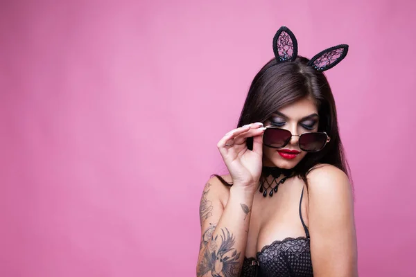 Aranyos szexi barna kampós füle nyúl és napszemüveg jelent a rózsaszín háttér — Stock Fotó