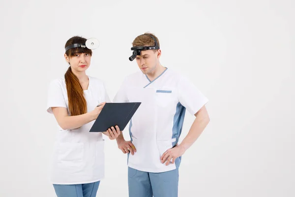 Personale medico. Ritratto di due otorinolaringoiatri che lavorano su uno sfondo bianco isolato che risolve vari problemi . — Foto Stock