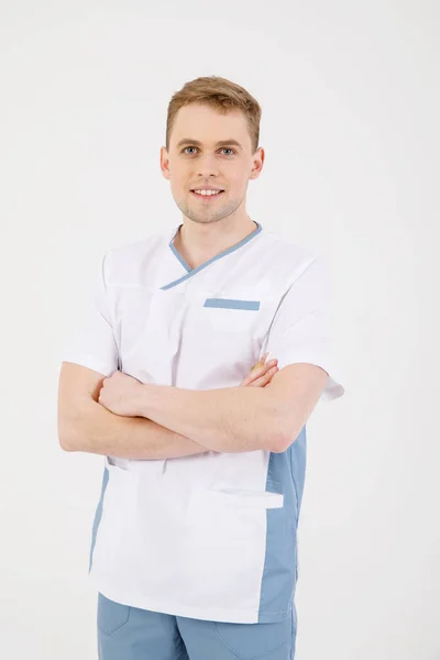 Personale medico. Giovane medico simpatico si trova isolato su uno sfondo bianco vestito in uniforme per i medici — Foto Stock