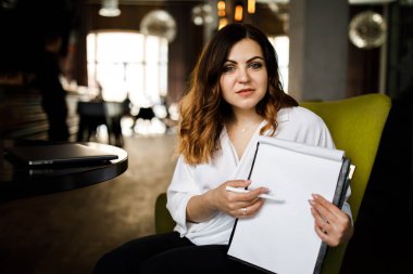 Ön manzara. Genç bir kadın kafede oturuyor, elinde kalem tutuyor, belgeleri okuyor. Bir iş kadını sözleşme imzalar. Girişimci, girişimci çalışıyor.