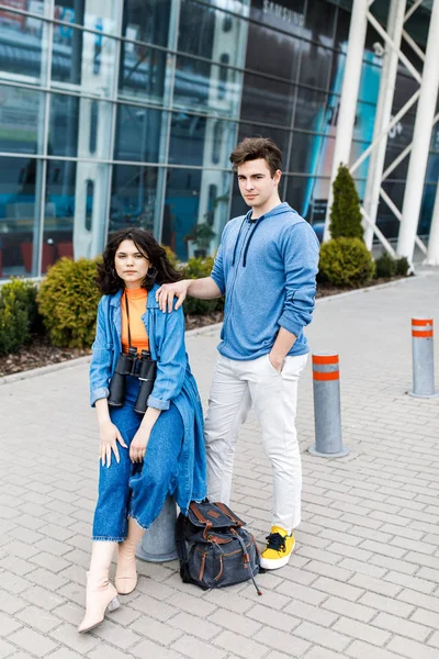 Jovem casal bonito - um menino e uma menina andando pela cidade com um binocular em suas mãos. Jovens viajam . — Fotografia de Stock