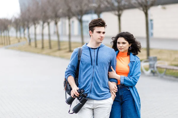 Young pretty couple - a boy and a girl walking around the city with a binocular in his hands. Young people travel. — 스톡 사진