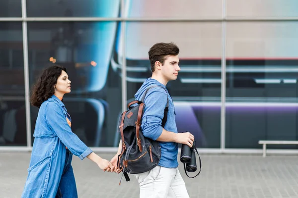 Una pareja joven y bonita - un niño y una niña caminando por la ciudad con un binocular en las manos. Jóvenes viajan . — Foto de Stock