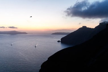 Santorini'de inanılmaz romantik gün batımı sahnesi. Gün batımından kısa bir süre önce