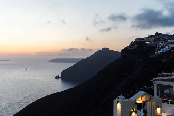 Ilha de Santorini romântica durante o pôr do sol, Grécia. Vista pitoresca da cidade de Santorini. Edifícios brancos, mar, montanhas. Férias românticas à beira-mar — Fotografia de Stock